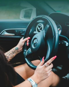 Person driving a Mercedes-Benz, hands on the steering wheel, representing the modern car-buying experience shaped by trust and decision confidence