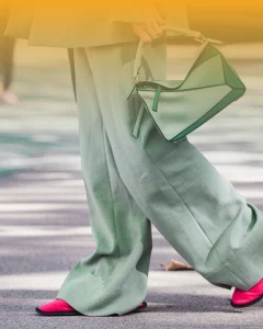 Business owner walking into a networking event wearing comfortable outfit and carrying a handbag, highlighting preparation and confidence for professional networking
